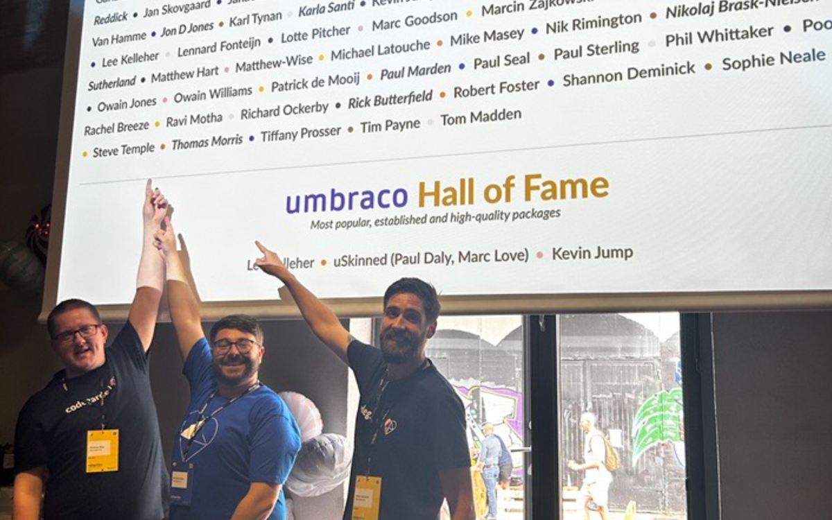 Matt Wise, Rick Buttefield and Danny Lancaster point as the Umbraco MVP slide where their names are displayed 