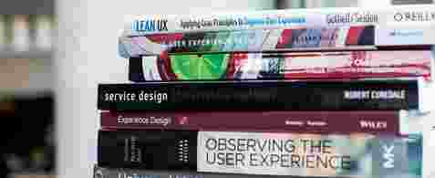 A stack of colourful user experience and service design books.