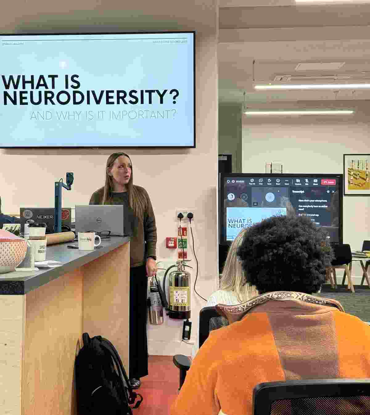 Neurodiversity consultant Rachel Morgan-Trimmer stands in the Nexer Digital office, presenting from a slide titled 'What is neurodiversity?'