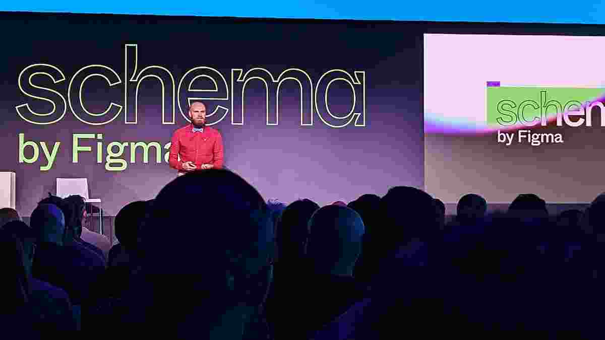 An audience seated in front of a stage with a speaker standing, and a slide reading "schema by Figma"